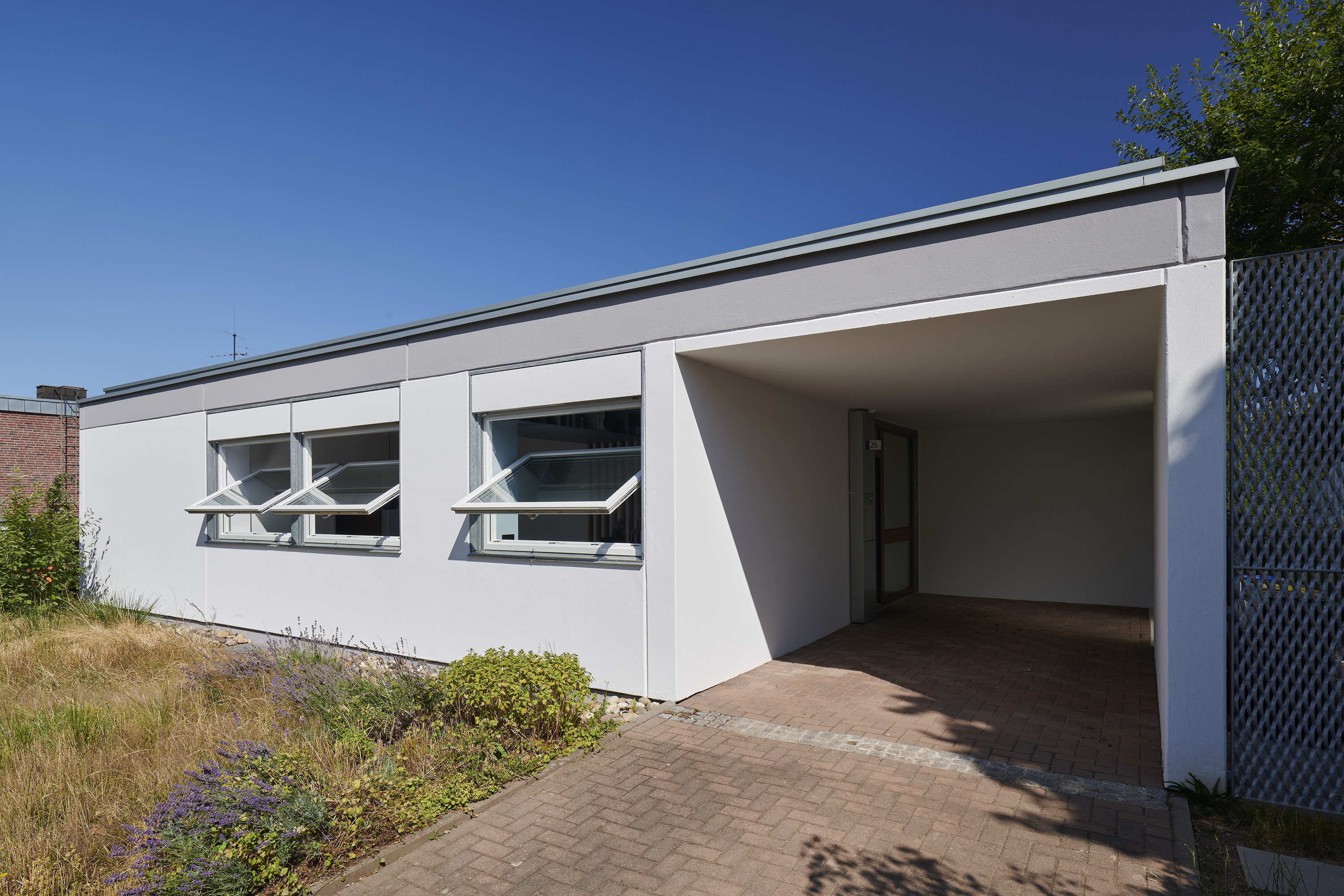 »Vorher/Nachher«: Dokumentation der Sanierung eines Camus-Dietsch Typ-Bungalows — Straßenansicht Südfassade nach der Sanierung mit wieder hergestellten, horizontalen Dreh-Kipp-Fenstern