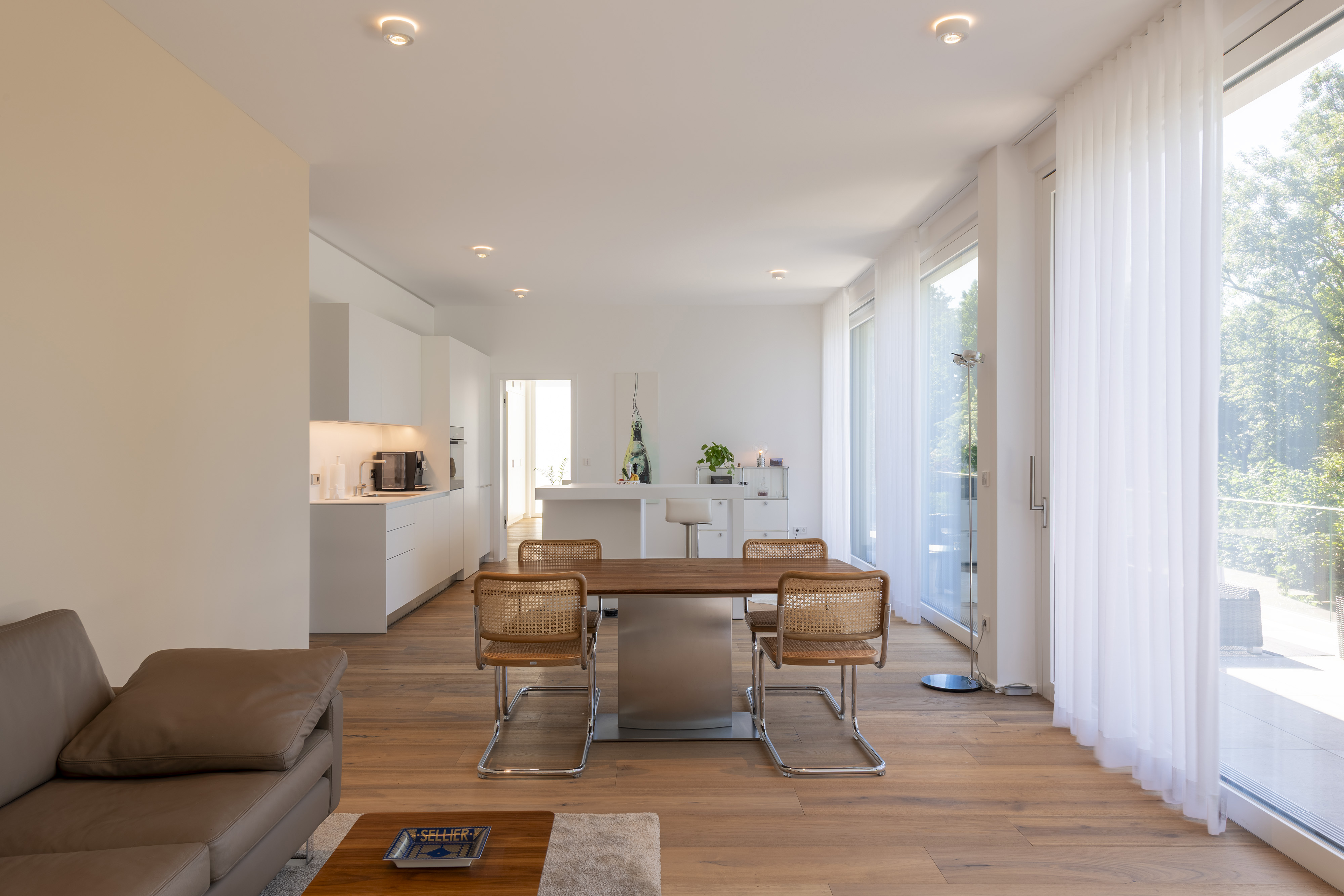 Haus L., Saarbrücken, Saarland — dieselbe Wohn-Ess-Küche nach dem Einzug, mit Esstisch und Sofa