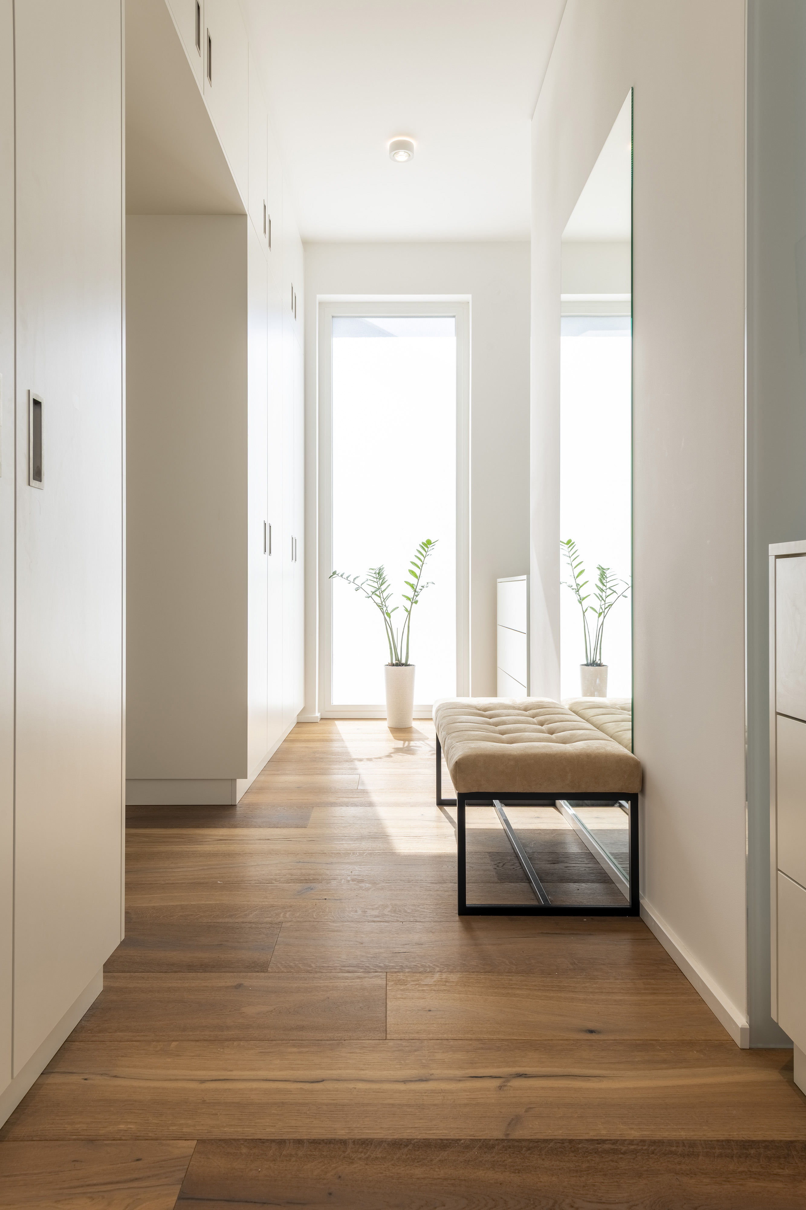 Haus L., Saarbrücken, Saarland — Garderobenflur nach dem Einzug, mit Einbauschränken, Spiegel und Sitzbank