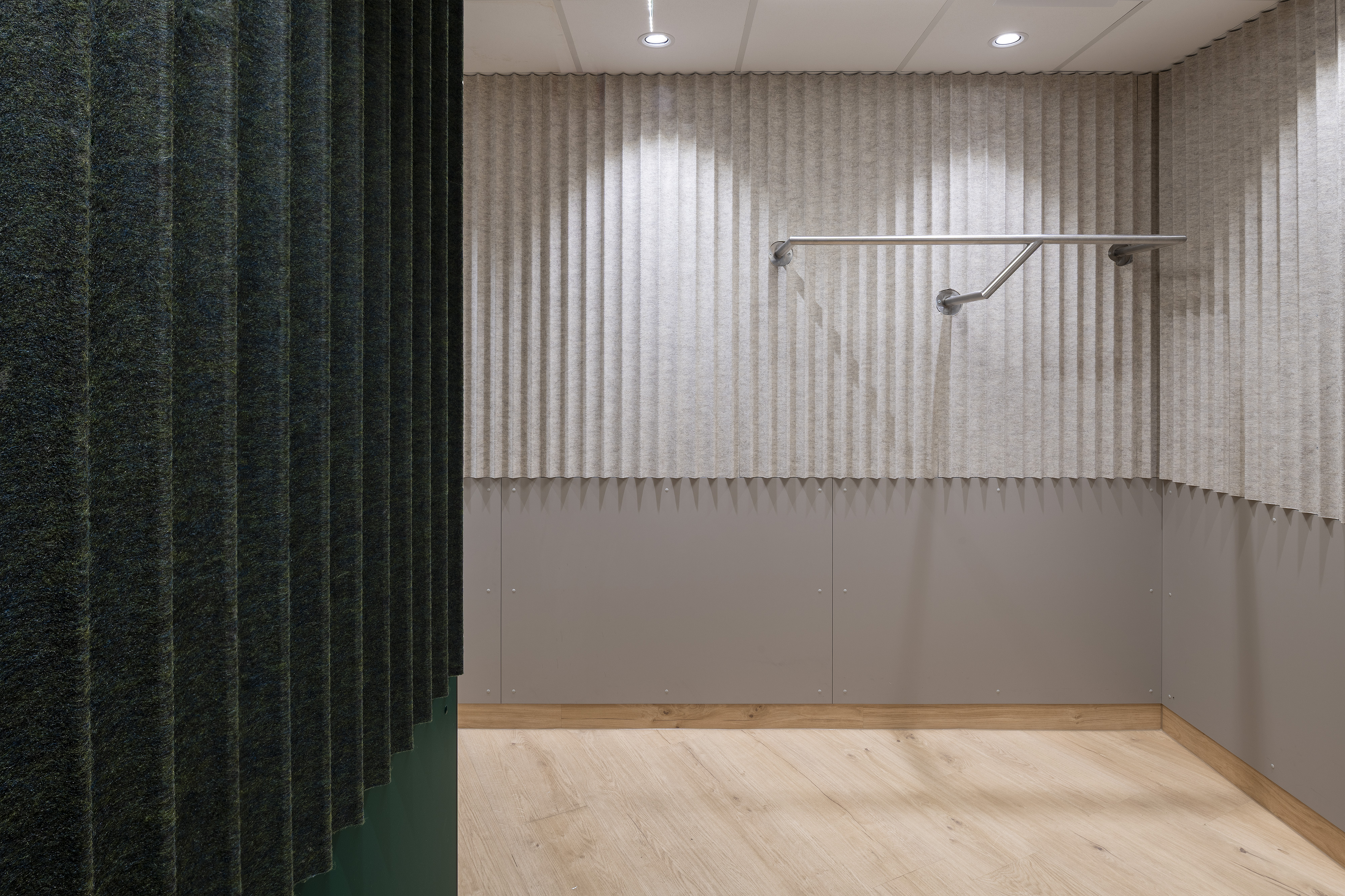 B. Braun Gesundheitszentrum Saarbrücken, Saarland — Nische mit Handlauf vor akustisch wirksamer Wandbekleidung, im Vordergrund die grüne Filzlamellenwand