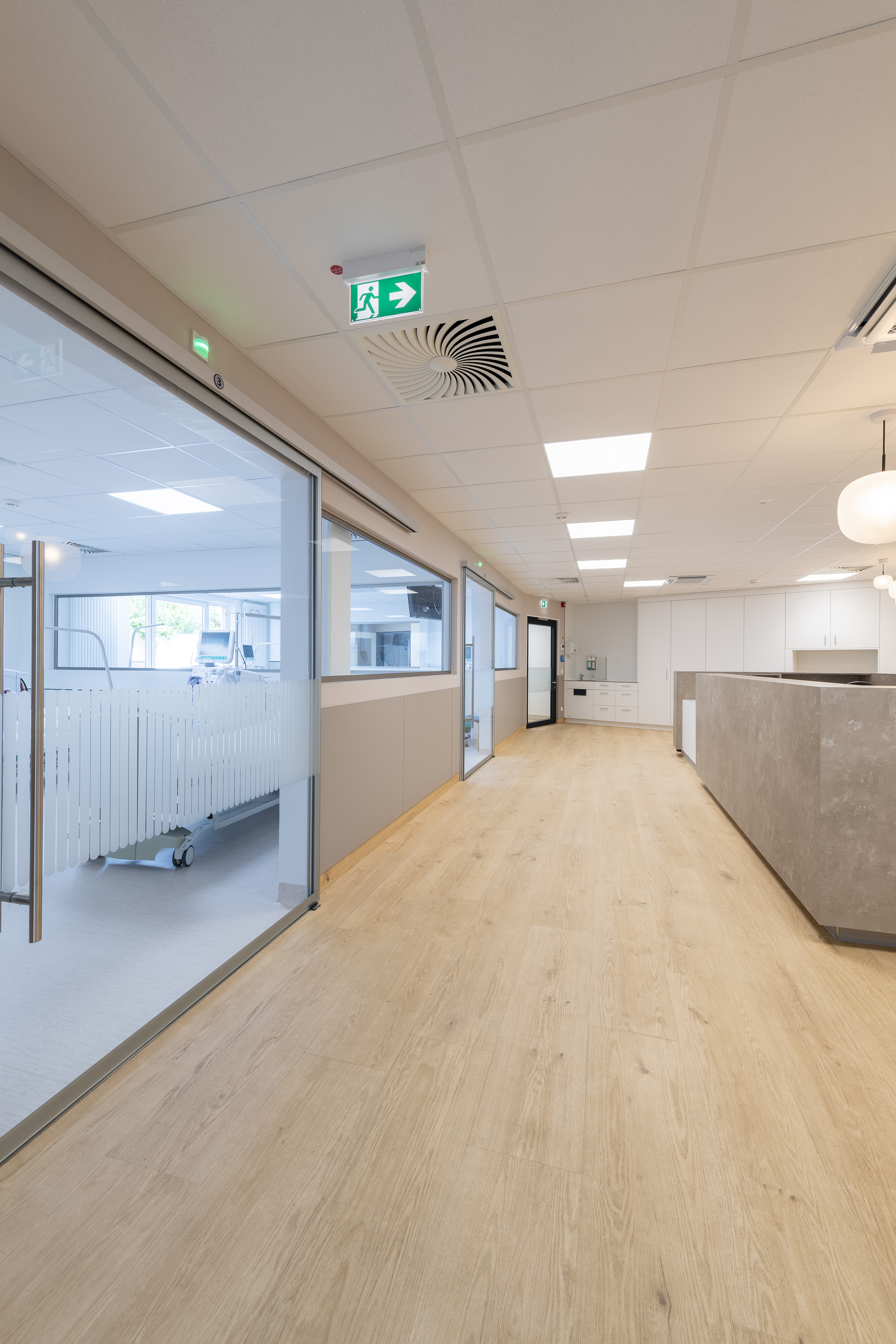 B. Braun Gesundheitszentrum Saarbrücken, Saarland — Flur mit verglastem Behandlungsraum und Blick zum Pflegestützpunkt
