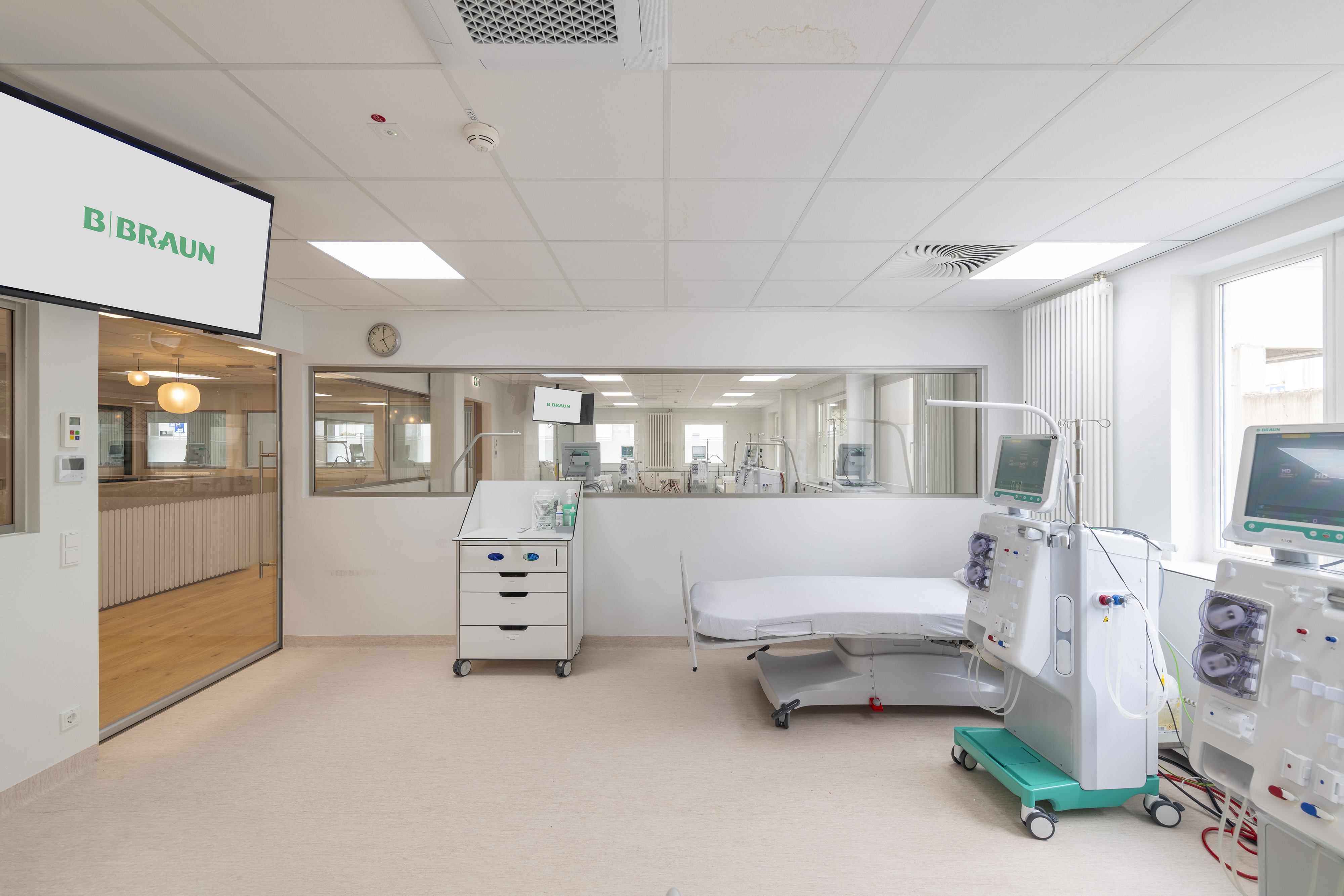 B. Braun Gesundheitszentrum Saarbrücken, Saarland — Dialyseplatz mit Gerät und Monitor, Sichtfenster zum Empfangsbereich