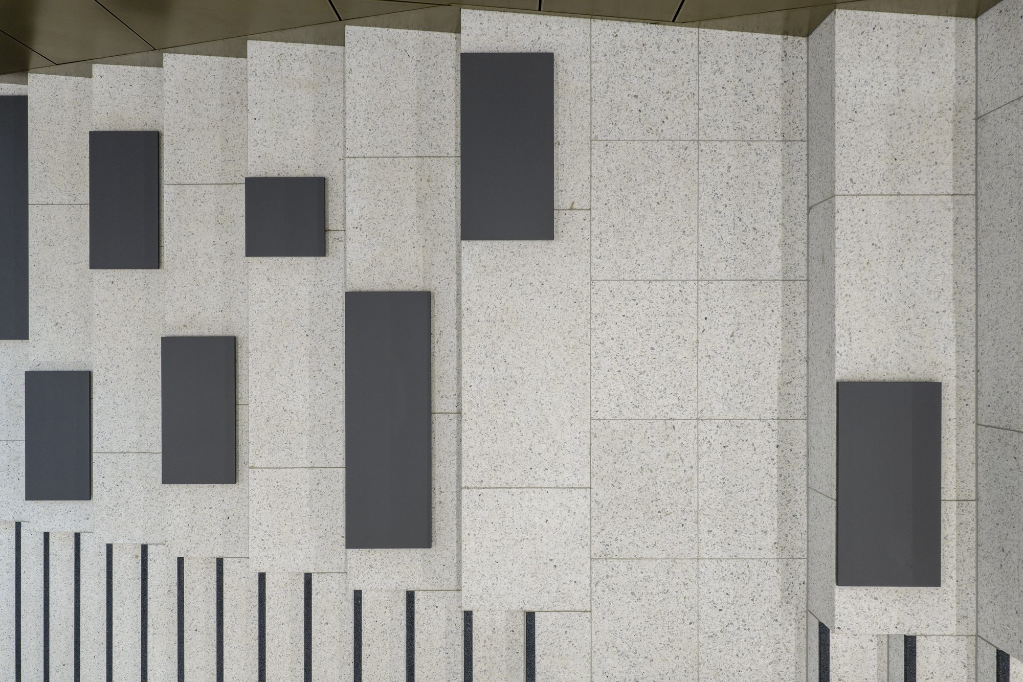 Architekturfotografie Zentrum für Biophysik ZBP, Saarbrücken — Sitztreppe im Foyer von oben: dunkle Sitzauflagen auf den hellen Werksteinblöcken, links die Treppenstufen
