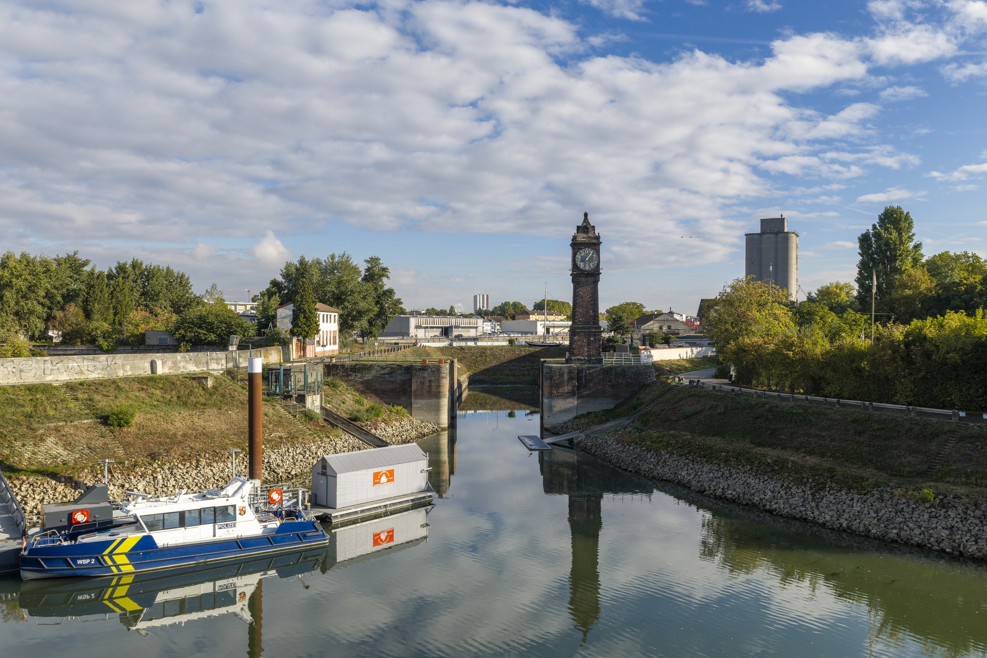 Kammerschleuse mit Pegelturm, Ludwigshafen am Rhein — Blick über das ruhige Hafenbecken auf Turm und Schleusenflanken