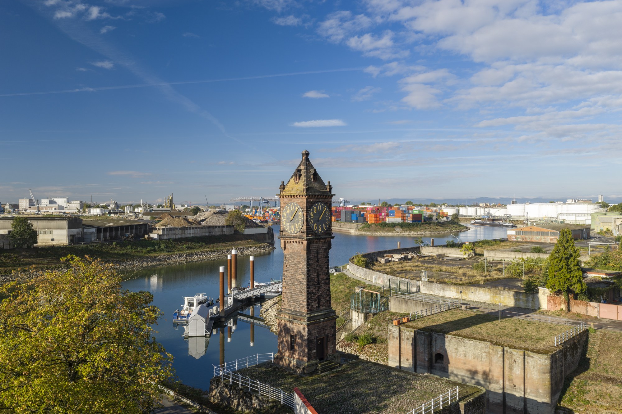 Kammerschleuse mit Pegelturm, Ludwigshafen am Rhein — der Sandsteinturm am Luitpoldhafen, dahinter Hafenbecken und Containerterminal