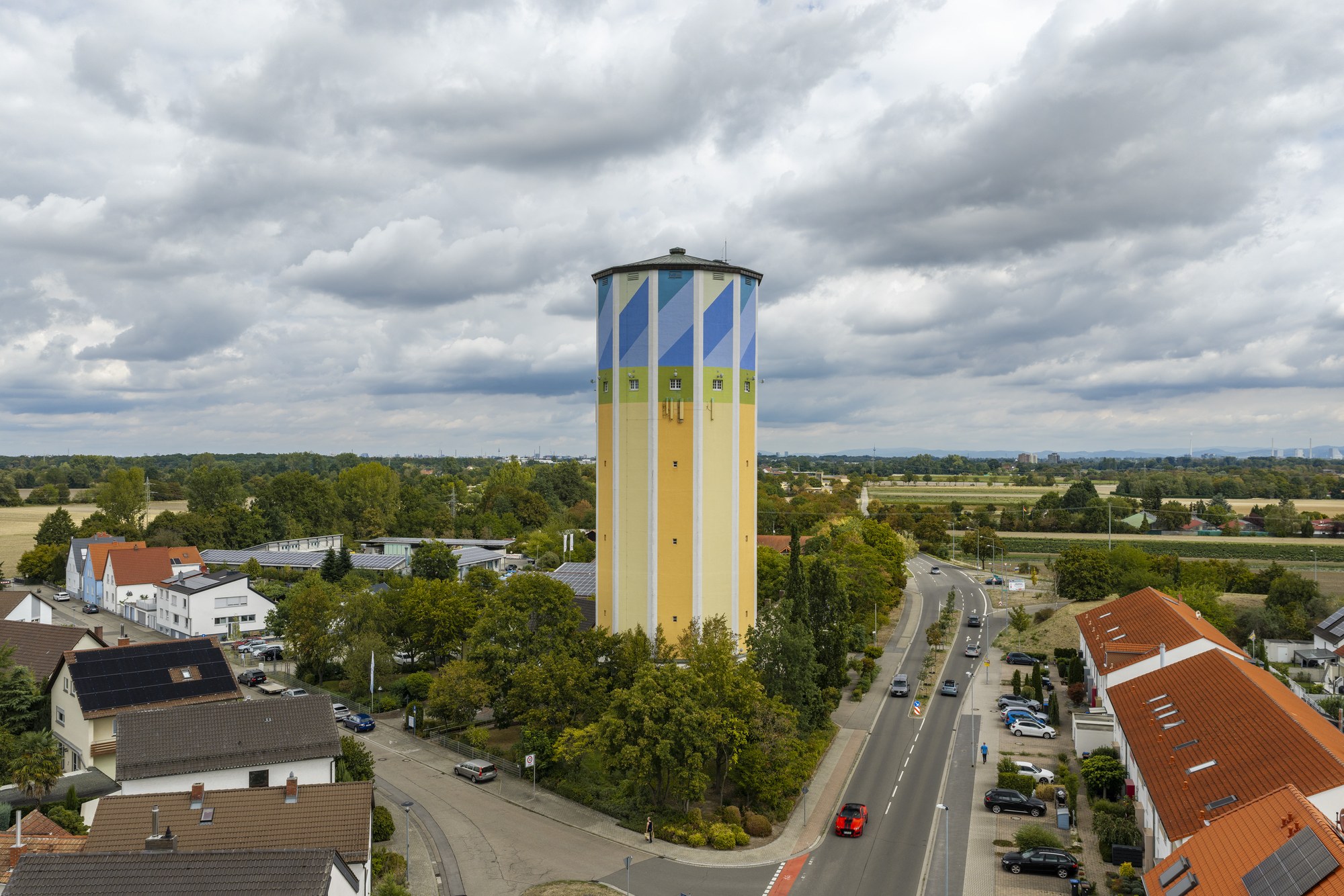 Wasserturm Schifferstadt — Luftbild des Turms über den Dächern des Orts, dahinter die offene Rheinebene