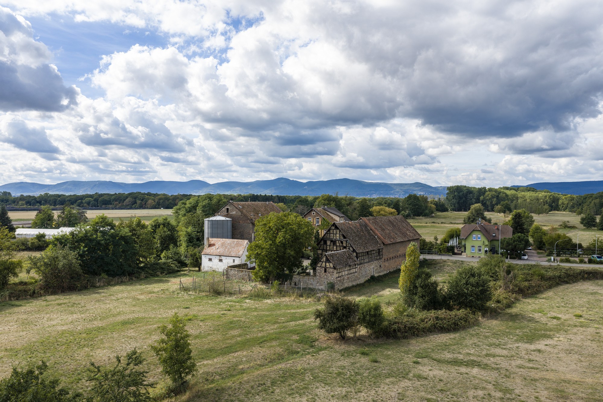 Fronmühle, Haßloch — Luftbild des Anwesens in freier Feldlage vor der Kulisse der Haardt