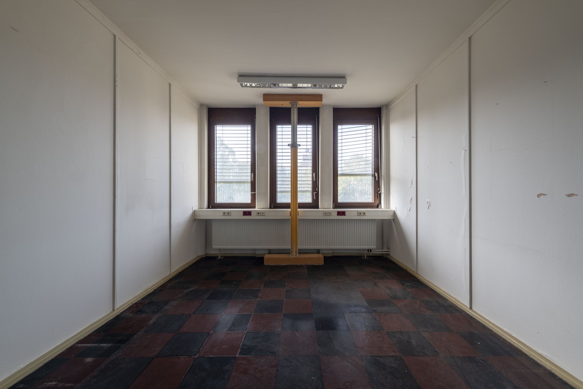 Ehemalige Französische Botschaft, Saarbrücken, Saarland — Leergeräumtes Büro mit drei Fenstern und gelben Baustempeln