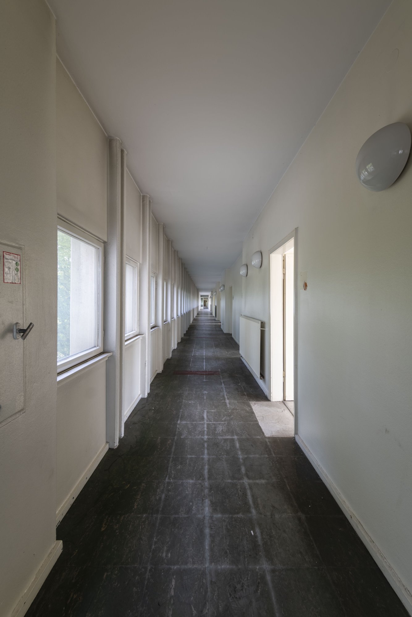 Ehemalige Französische Botschaft, Saarbrücken, Saarland — Rund hundert Meter langer Flur im Bürohochhaus mit dunklem Bodenbelag