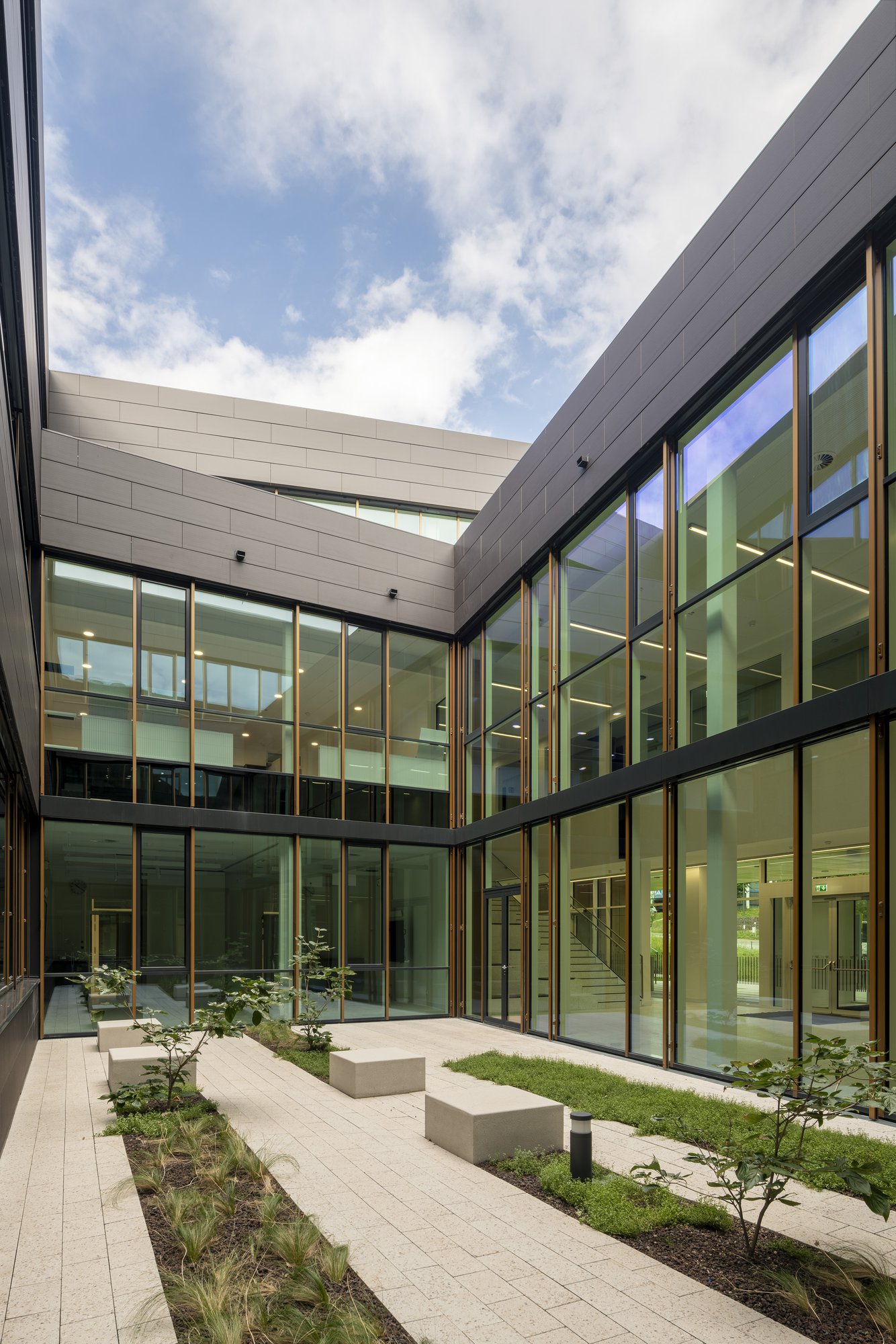 Architekturfotografie Zentrum für Biophysik ZBP, Saarbrücken — Begrünter Innenhof mit umlaufender Glasfassade und Sitzblöcken