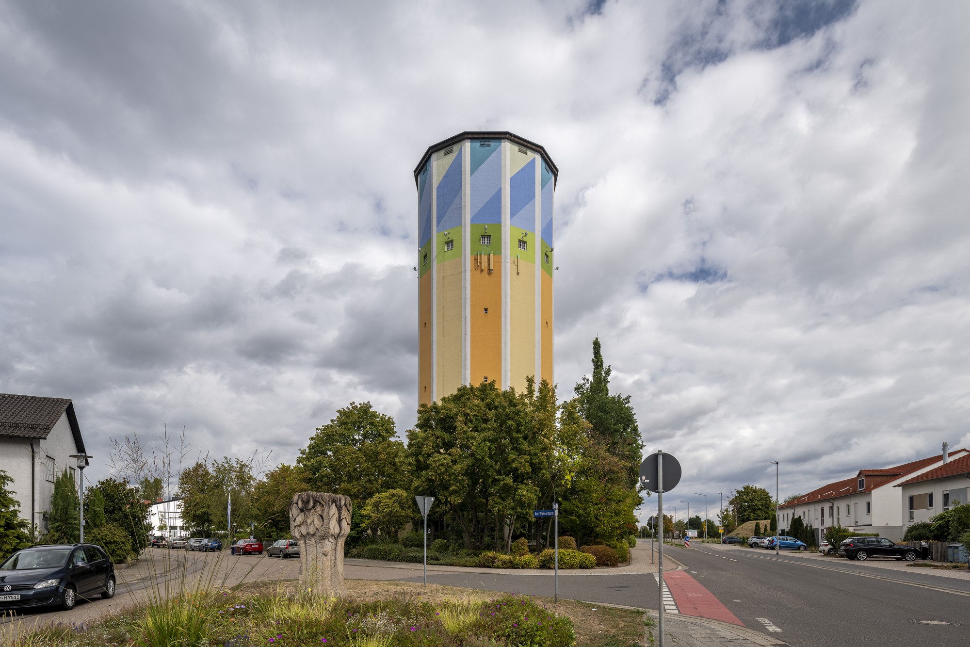 Wasserturm Schifferstadt — der farbig bemalte zwölfseitige Turm über einer Baumgruppe an der Mannheimer Straße