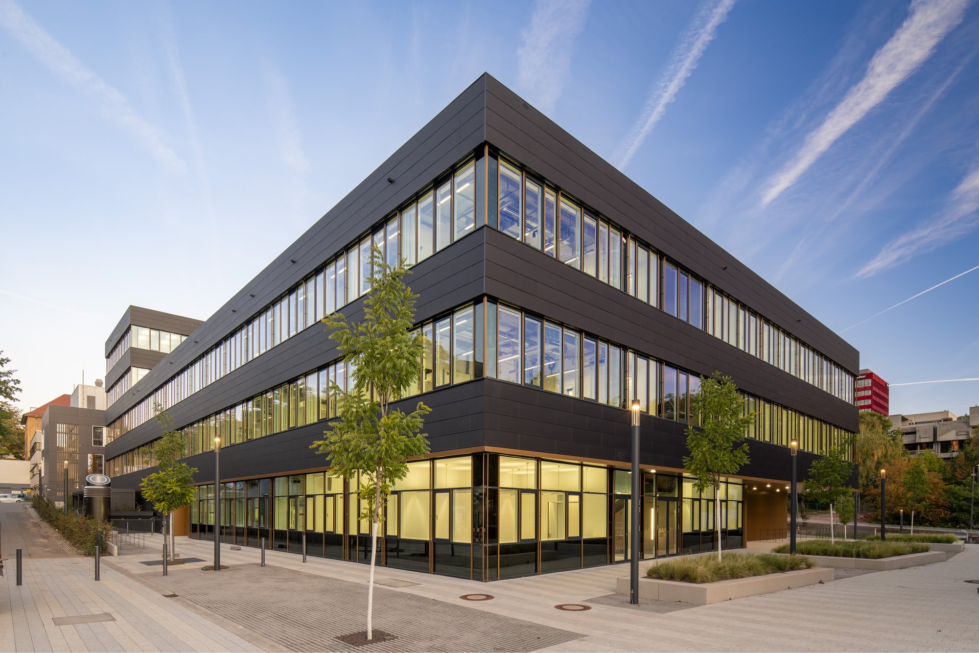 Architekturfotografie Zentrum für Biophysik ZBP, Saarbrücken — Nordostecke des Neubaus mit jungen Bäumen und dem verglasten Sockelgeschoss