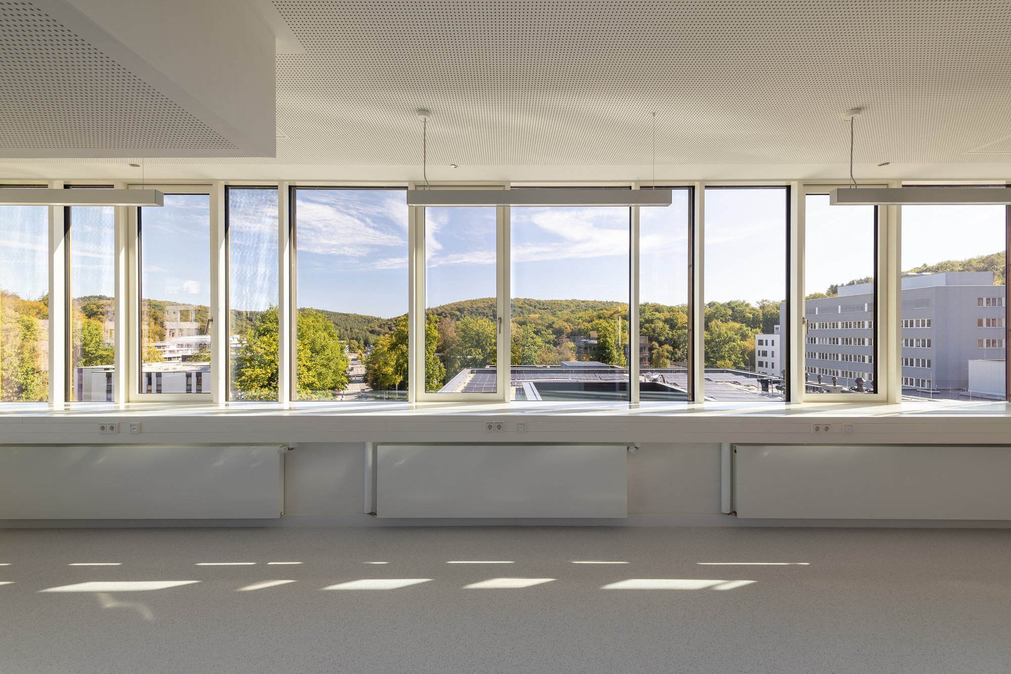 Architekturfotografie Zentrum für Biophysik ZBP, Saarbrücken — Unmöblierter Arbeitsraum mit Eckfenster und Ausblick über den Campus