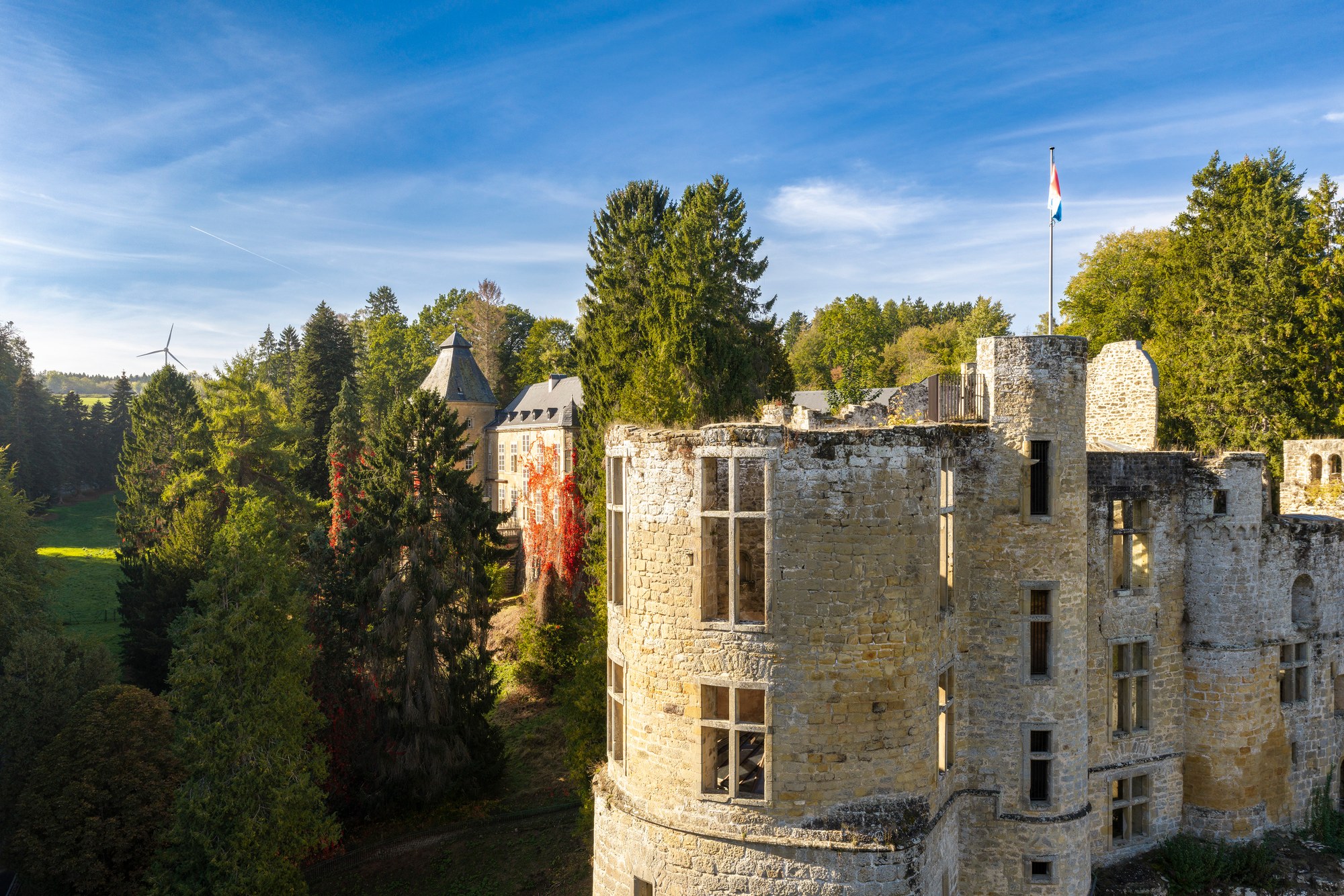 Architekturfotografie Burg Beaufort — Luftbild des Rundturms, links dahinter das Renaissanceschloss