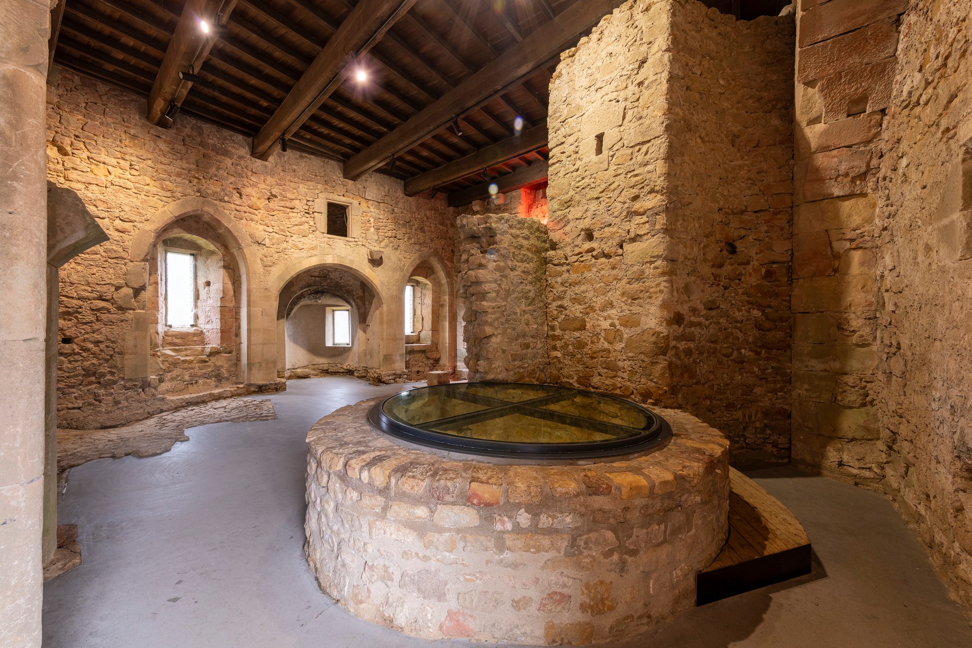 Architekturfotografie Criechinger Haus, Burg Larochette — gemauerter Brunnenkranz mit Glasabdeckung in der ehemaligen Küche