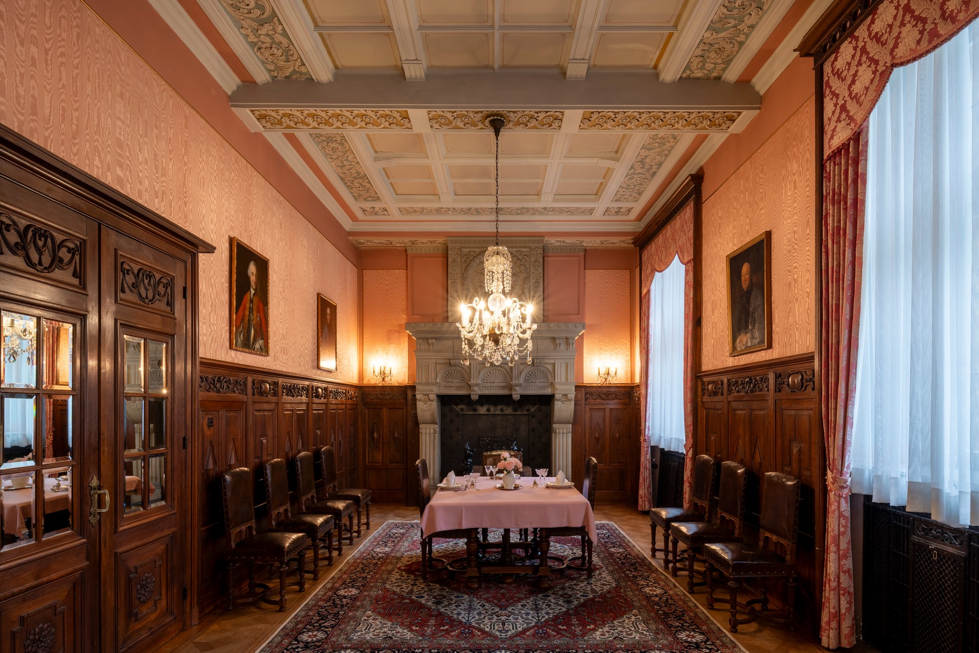 Architekturfotografie Renaissanceschloss Beaufort — Speisesaal mit Kassettendecke, Steinkamin, Kronleuchter und gedeckter Tafel