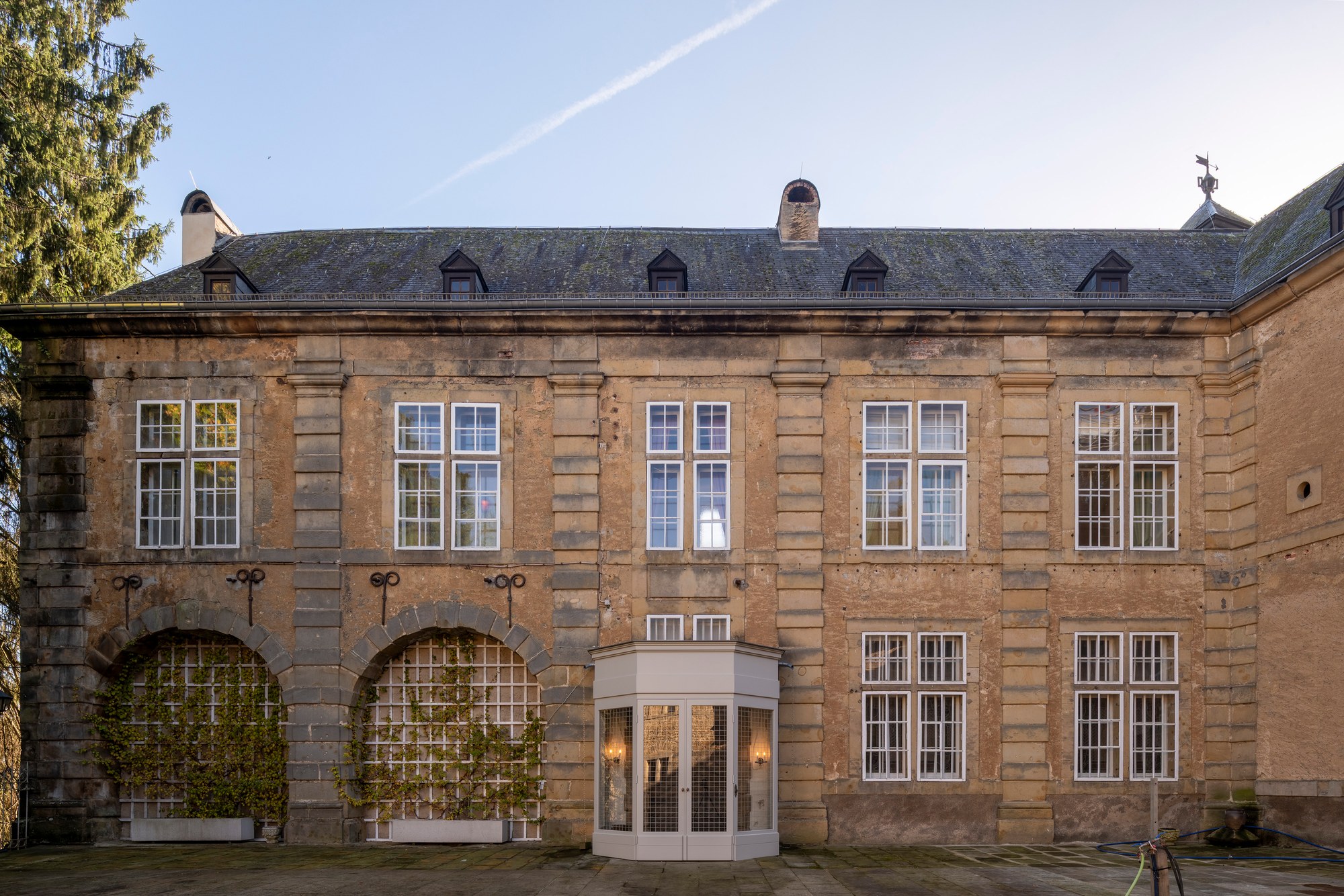 Architekturfotografie Renaissanceschloss Beaufort — Hoffassade mit vergitterten Bogenfeldern und verglastem Eingangspavillon